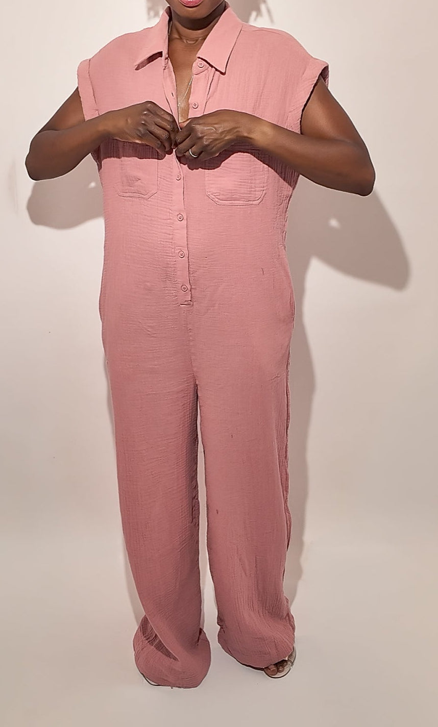 Person wearing a pink jumpsuit against a white background