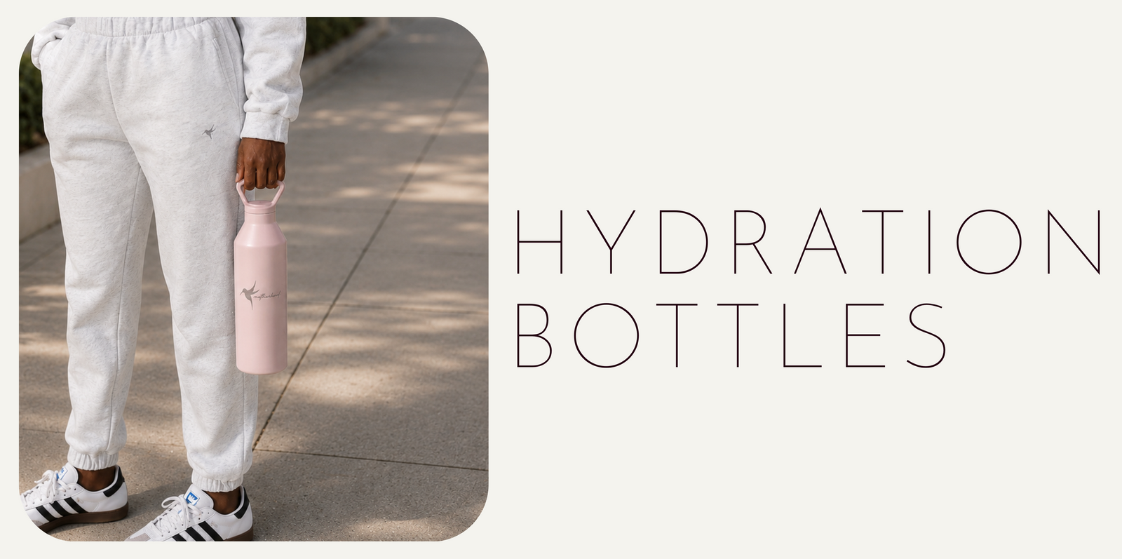 Person in our light grey softwear sweat set holding our pink hydration bottle.  The title text 'HYDRATION BOTTLES' is next to the person on a white background